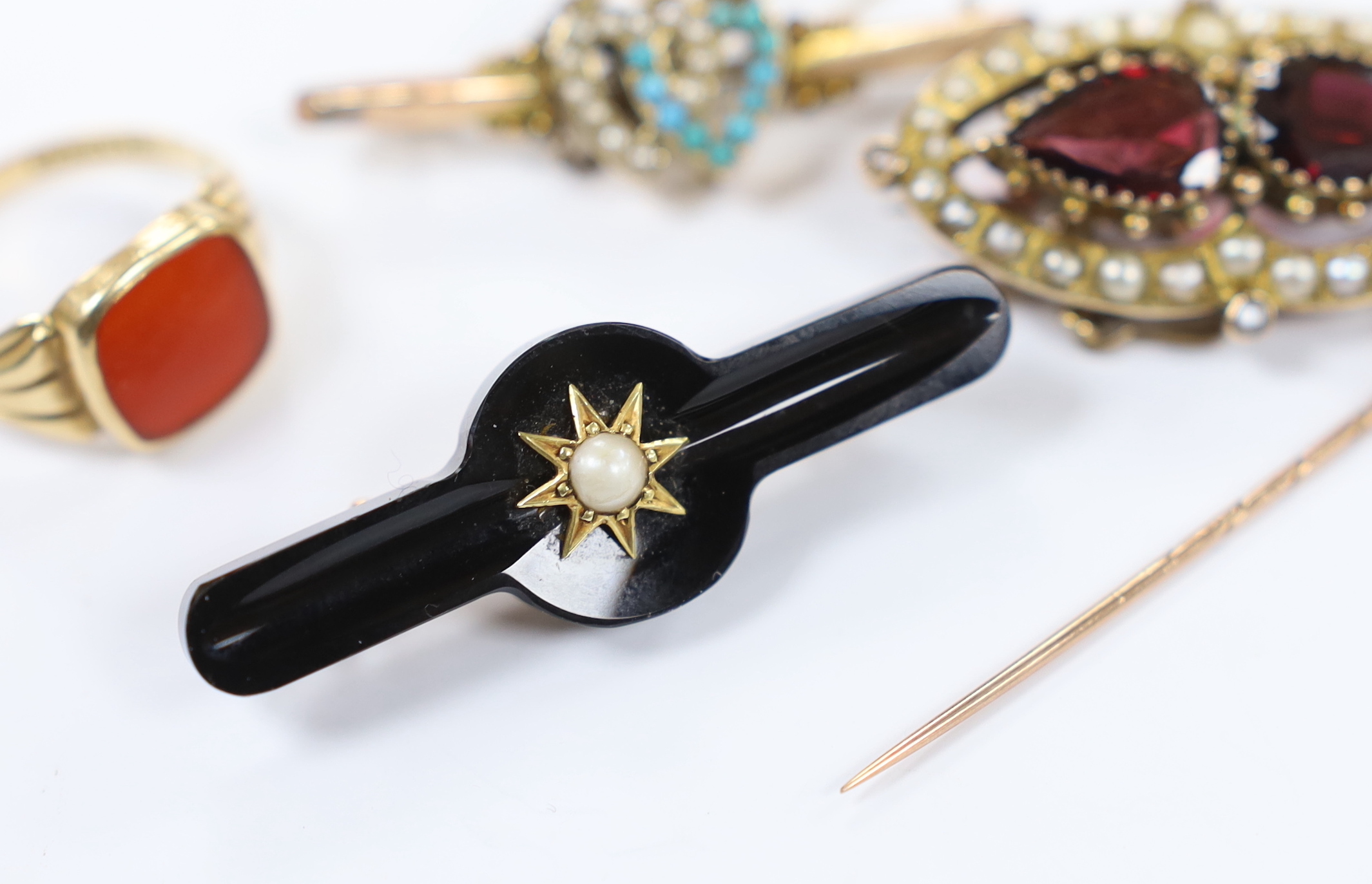 A 14k and carnelian set signet ring, size R/S, 3.1 grams, a Victorian yellow metal, two stone garnet and split pearl cluster set brooch, two other 9ct and gem set bar brooches including twin hearts and a 15ct and gem set